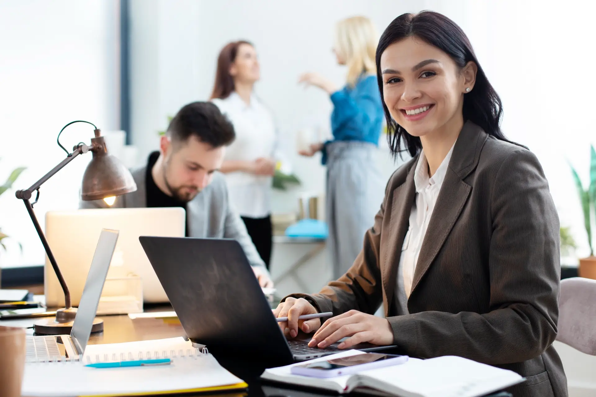 professionals working in a modern office with laptops and documents