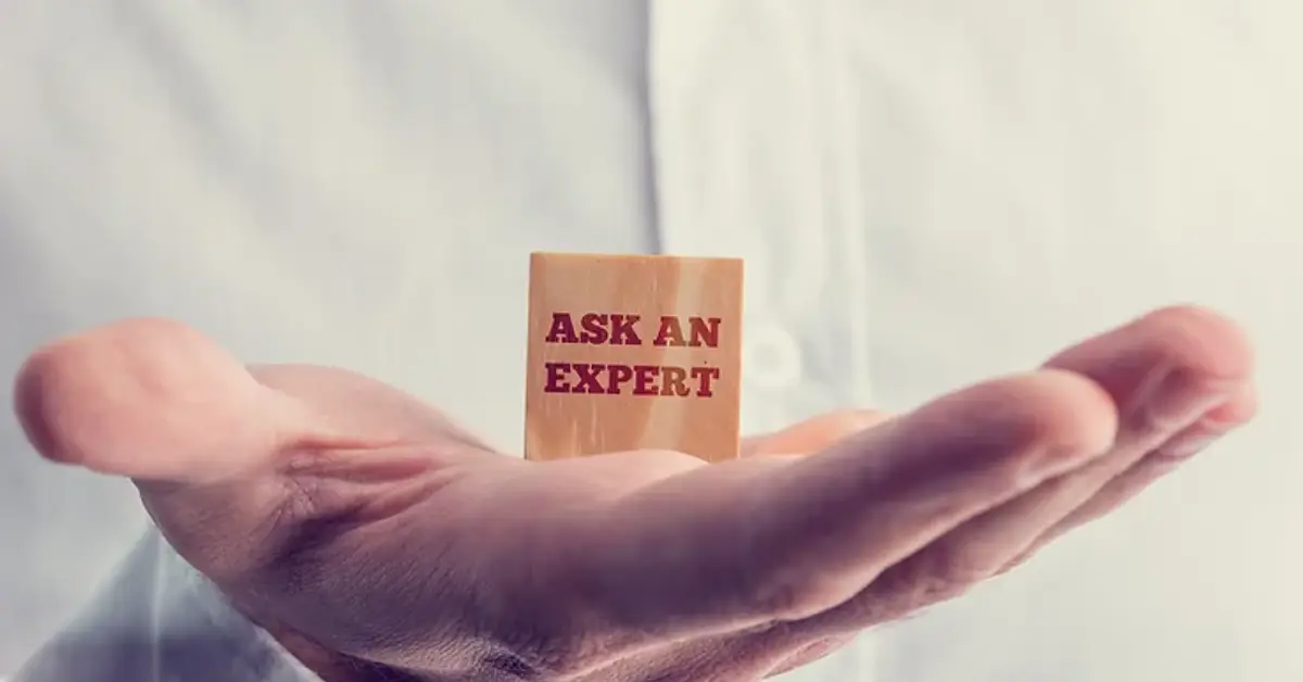 open-hand-presenting-a-wooden-block-with-ask-an-expert-text