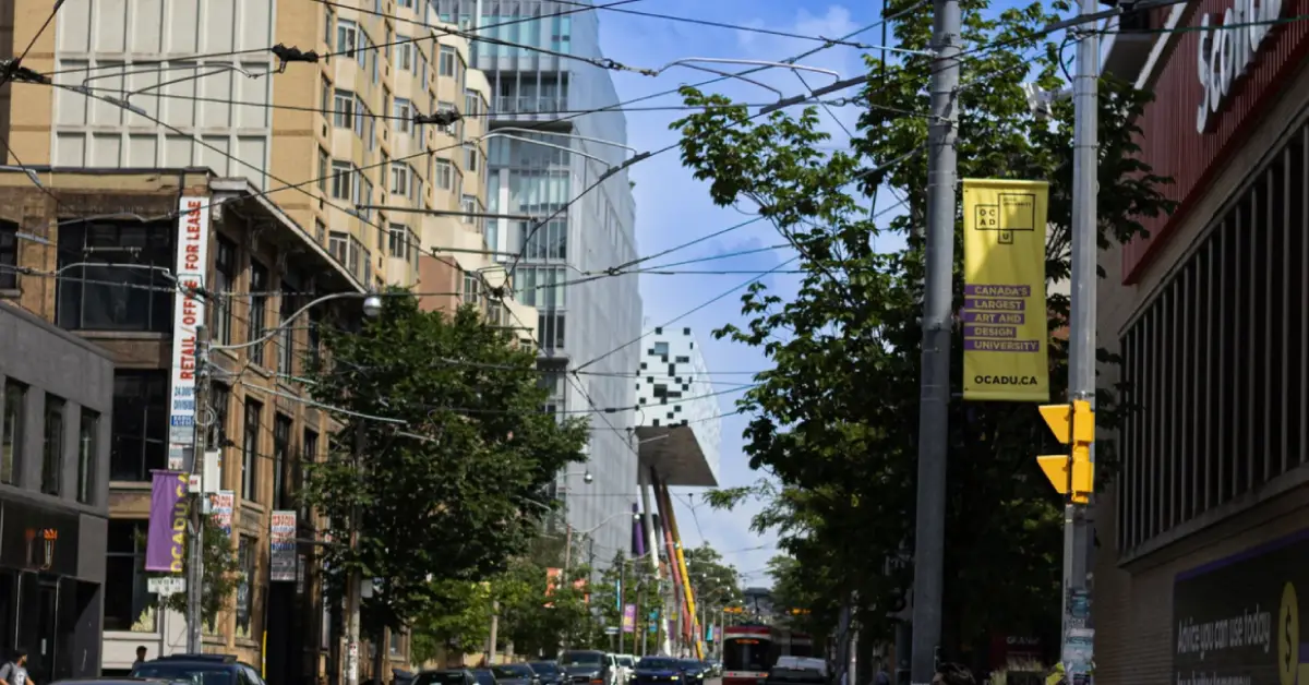 A-busy-urban-street-scene-with-modern-buildings-streetcars-and-pedestrians-crossing-near-OCAD-University-on-a-sunny-day