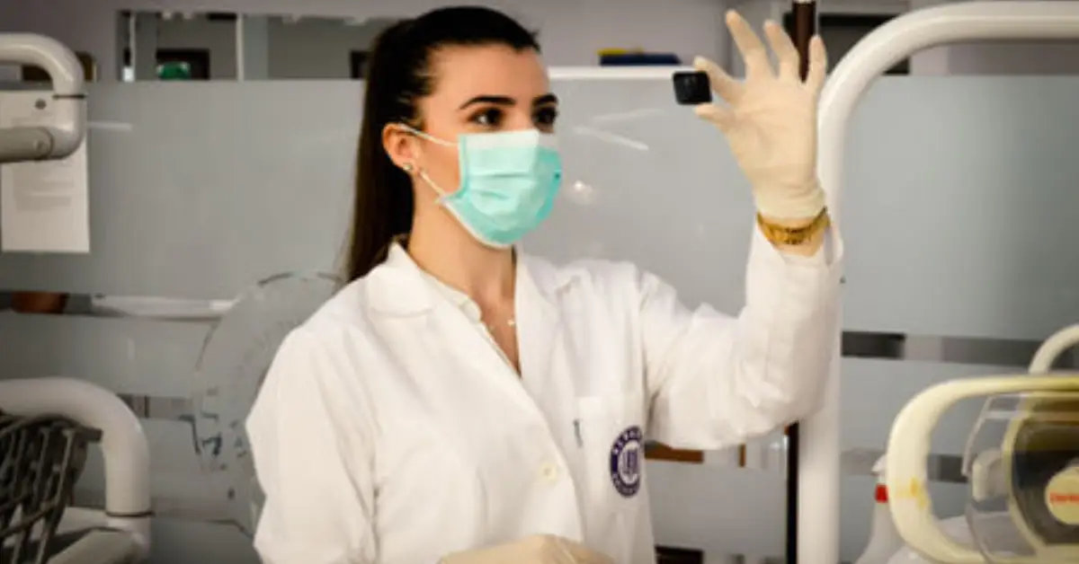 A-professional-in-a-lab-coat-holds-a-small-black-object-observing-it-intently-in-a-modern-laboratory-setting